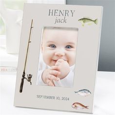 a baby is holding a fishing rod in front of a picture frame that says henry jack