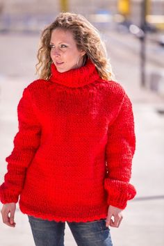 a woman wearing a red sweater and jeans