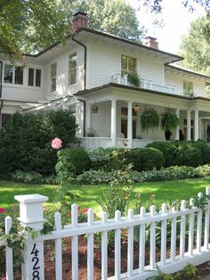 a white picket fence in front of a large house