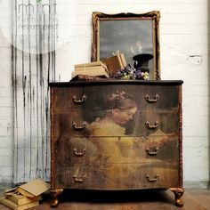 an old dresser with a painting on it