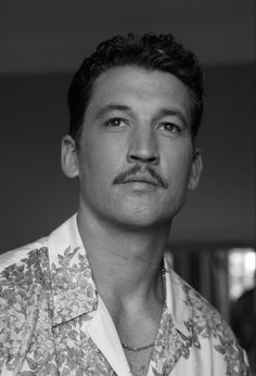 a black and white photo of a man with a moustache on his face