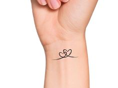 a woman's wrist tattoo with two hearts on it