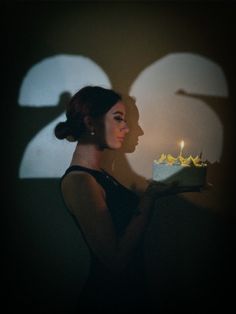 a woman holding a cake with lit candles