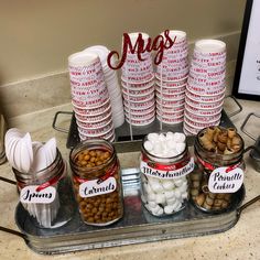 there are many jars with food in them on the tray and one is filled with marshmallows