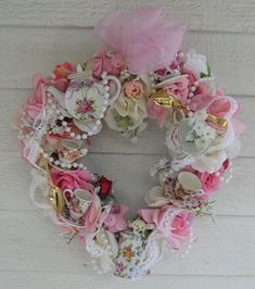 a pink and white wreath hanging on the side of a building