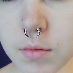 a close up of a person with a nose ring and piercing on it's nose