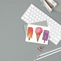 three ice cream pops stickers sitting on top of a desk next to a keyboard