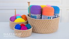 crochet baskets with yarn and knitting needles in them sitting on a white table