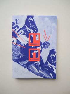 a blue and orange book with an image of two skiers in the mountains on it