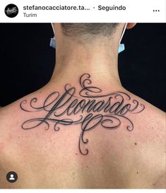 the back of a man's neck with an upper and lower case tattoo on it