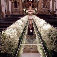 the inside of a church with flowers on the pews and an aisle leading up to it