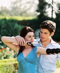 a young man and woman are aiming an arrow at each other