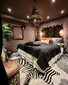 a bedroom with a zebra print rug and chandelier hanging from the ceiling over the bed