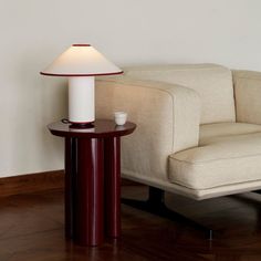 a lamp sitting on top of a table next to a couch