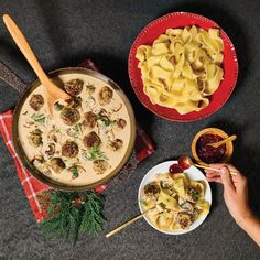 two bowls of pasta and meatballs on a table next to a bowl of sauce