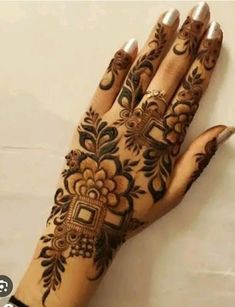 a woman's hand with henna tattoos on it