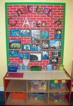 there is a red brick wall with pictures on it and plastic bins under the shelf