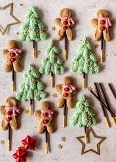 decorated cookies are arranged on sticks and placed next to christmas trees, stars and snowflakes