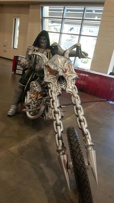 a person on a motorcycle that is made out of chains and metal parts with spikes