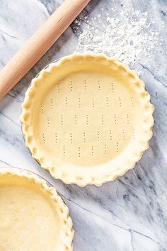 two pie pans sitting on top of a marble counter