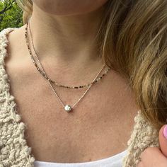 This simple circle charm necklace is the perfect minimalist every day jewelry. The elegant sterling silver dot charm floats on a sterling silver bead chain for a great feminine classy look. Sterling Silver Focal Bead - 6mm Choose your length at checkout! Model is wearing 18 inches Jasper Necklace as shown in photos: https://www.etsy.com/listing/1471325157/layering-necklace-fancy-jasper-beaded?click_key=e2a7461b0b24e4766d5ab61279a7dbfaeb15f0e2%3A1471325157&click_sum=26b804b0&ref=shop_home_active_1&pro=1&frs=1 To view more of my original jewelry designs, visit: https://www.etsy.com/shop/TheBeadCounter Silver Charm Necklace With Satellite Chain, Silver Dainty Charm Necklace For Layering, Silver Charm Necklace With Round Pendant And Satellite Chain, Silver Minimalist Charm Necklace For Layering, Everyday Silver Jewelry With Tiny Beads, Minimalist Double Strand Charm Necklace, Sterling Silver Charm Necklaces For Layering, Sterling Silver Round Charm Necklaces For Layering, Everyday Double Strand Minimalist Charm Necklace