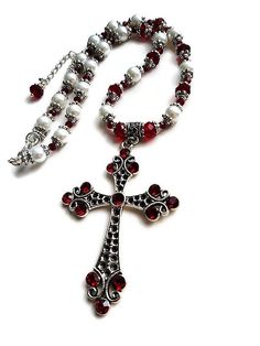 Wonderfully capturing the essence of the Renaissance Tudor style with a very elaborate design this OOAK ox blood red and white pearl cross necklace graces the neck with Victorian elegance. A unique statement timeless piece of jewelry with a royal feel. A glamorous bridal choker necklace for a Gothic wedding. Shimmering with a rich crimson red glow, this dazzling intricate pendant necklace with a delightful vintage appeal and flashing sparkles with every movement features an absolutely stunning a Victorian Cross Necklace, Elegant Red Cross Pendant Jewelry, Pearl Cross Necklace, Baroque Jewelry, Large Pendant Necklace, Bridal Choker, White Jewelry, Fancy Jewelry, Red Crystals