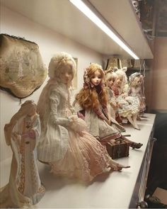 there are many dolls lined up on the shelf in front of each other and one is holding a purse