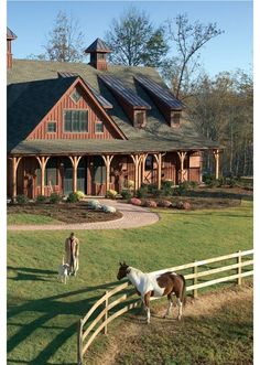 two horses standing in front of a large house