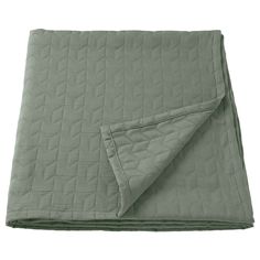 a blanket that is folded up on top of a white surface with a light green color