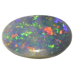 a black opal stone with green and orange flecks on the inside, against a white background