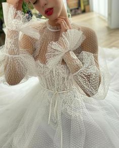 a woman wearing a white dress and holding her hands to her face while posing for the camera