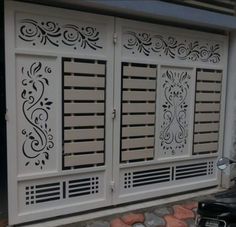 a motorcycle parked in front of a white building with decorative designs on it's doors