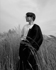 black and white photograph of a man standing in tall grass