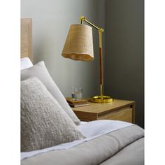 a lamp on a nightstand next to a bed