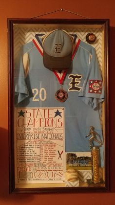 a baseball uniform is hanging on the wall with other items around it, including a hat and glove