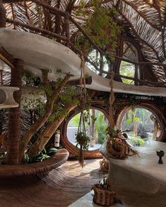 the inside of a tropical house with hanging plants and hammock beds in it