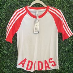 Jersey Style Shirtlogo At The Bottom. Cotton Moisture Whisking Material. White And Coral Color. Never Worn. Nwt Summer Adidas Logo Top, Adidas Logo Summer Top, Adidas Logo Tops For Spring, Adidas Summer Tops With Three Stripes, Adidas Three Stripes Summer Tops, White Adidas Tops For Spring, Adidas Logo Tops, White Logo Print Shirt For Spring, Spring Cotton Top With Adidas Logo