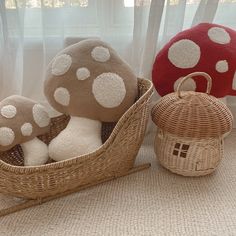 three stuffed mushrooms sitting in a basket next to each other on the floor near a window