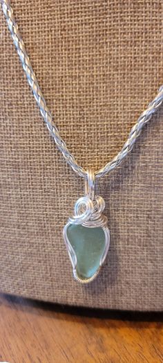 This genuine piece of Maine sea glass is handcrafted in sterling silver. No two pendants will ever be the same. This pendant comes with an 18' leather chain (as shown) that is handmade by US Veterans. Unique Silver Jewelry With Recycled Glass, Handmade Silver Recycled Glass Necklace, Handmade Silver Necklace With Recycled Glass, Nickel-free Silver Necklace Of Recycled Glass, Nickel-free Silver Necklaces Made Of Recycled Glass, Nickel-free Silver Necklaces With Recycled Glass, Nickel Free Silver Necklace Of Recycled Glass, Silver Sea Glass Round Pendant Jewelry, Wire Wrapped Silver Recycled Glass Jewelry