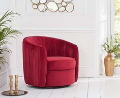 a red chair sitting next to a potted plant