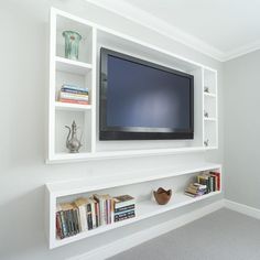 a flat screen tv mounted to the side of a white bookcase in a living room