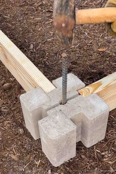 a hammer is hitting concrete blocks with a nail