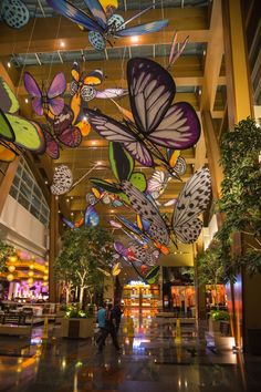 the inside of a large building with many colorful butterflies hanging from it's ceiling