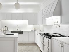 a kitchen with white cabinets and black appliances