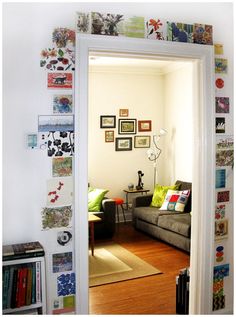 a living room filled with furniture and lots of pictures on the wall next to a doorway