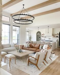 a living room filled with lots of furniture and a chandelier hanging from the ceiling