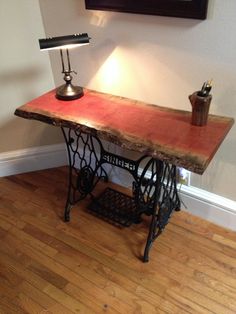 an old sewing machine table with a lamp on top