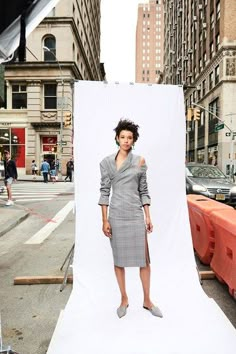 a woman standing in front of a white backdrop with an image of herself on it