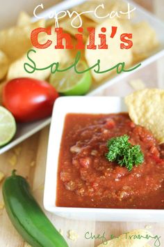 a white bowl filled with salsa next to tortilla chips and a green pepper