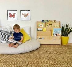 a little boy sitting on a bean bag chair reading a book